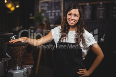 Pretty waitress posing next to coffee machine