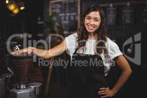 Pretty waitress posing next to coffee machine