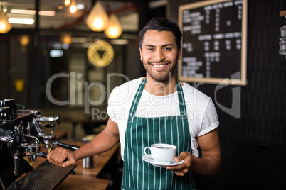 Smiling barista making coffee with coffee machine