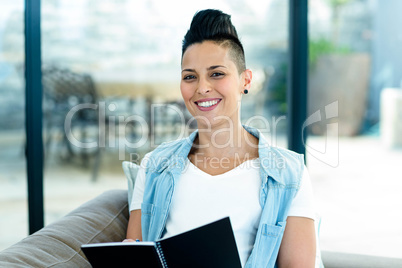 portrait of pregnant woman writing on notepad
