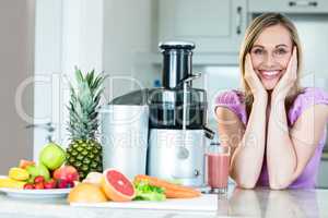 Blonde woman drinking a smoothie in the kitchen