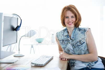 smiling hipster woman sitting at a desk