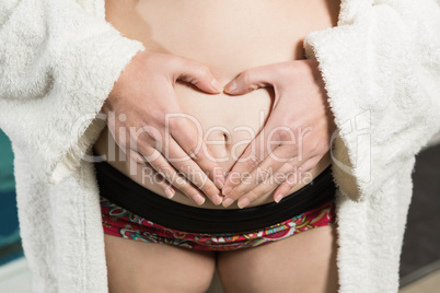 Pregnant woman making heart shape with hands