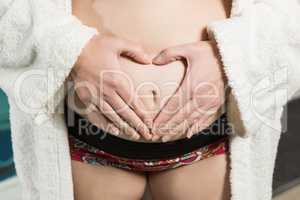 Pregnant woman making heart shape with hands