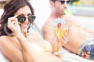Young couple sitting on sun loungers