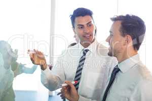 Businesspeople writing on white board