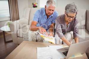 Senior woman paying bills online on laptop