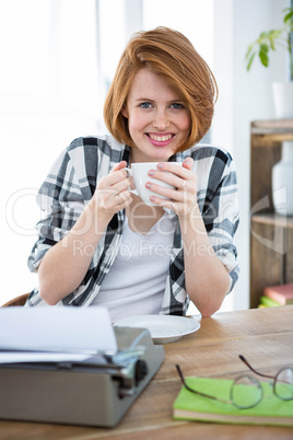 smiling hipster woman drinking a  cup of coffee