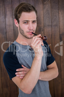 Handsome hipster smoking pipe