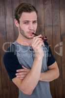 Handsome hipster smoking pipe