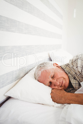 Senior man sleeping on bed