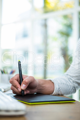 Masculine hands writing on digital tablet
