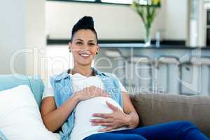 Pregnant woman relaxing on sofa in living room