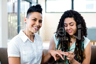 Woman putting a ring on her partners finger