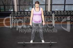 Determined woman looking at barbell