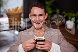 Smiling man is holding a cup of coffee
