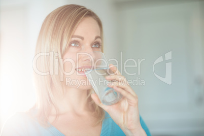 Pretty blonde woman drinking a glass of water