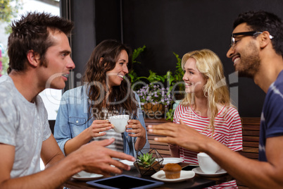 Smiling friends enjoying coffee together