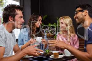 Smiling friends enjoying coffee together