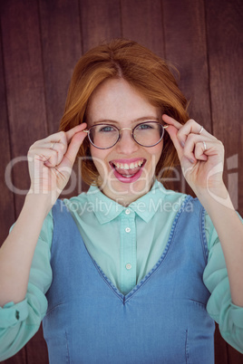 Red-haired hipster woman holding her glasses