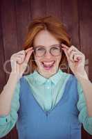 Red-haired hipster woman holding her glasses