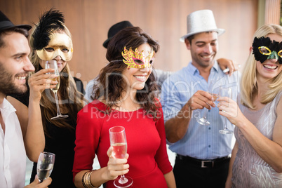 Friends with masks on holding champagne glasses