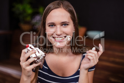 Happy woman holding piece of cake