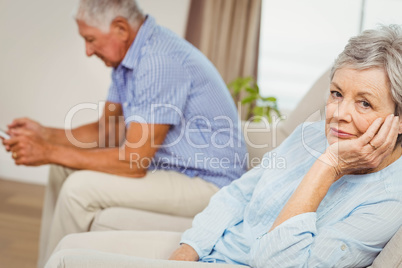 Worried senior woman sitting on sofa