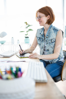 smiling hipster business woman writing on her tablet