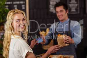 Portrait of a smiling woman paying with credit card