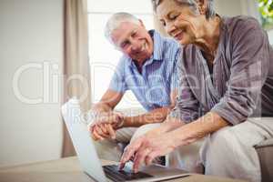 Senior woman using laptop in living room