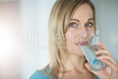 Pretty blonde woman drinking a glass of water