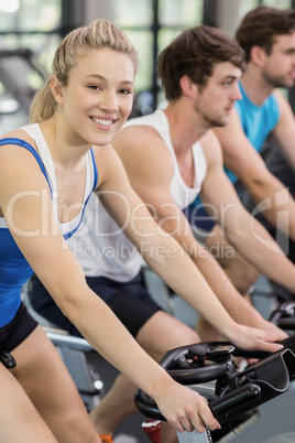 Fit group of people using exercise bike together