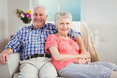 Senior couple sitting on sofa and smiling