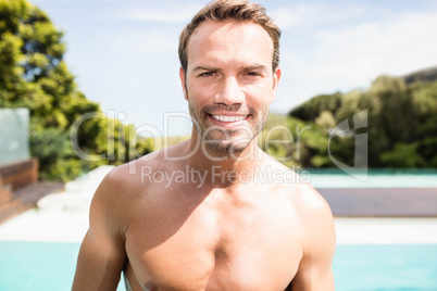 Young man smiling near poolside
