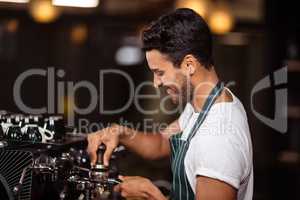 Smiling barista preparing coffee with a machine