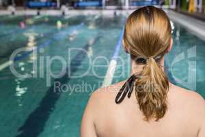Rear view of woman sitting on the edge of the pool