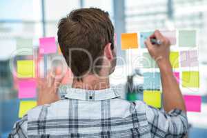 Hipster man writing on post-it