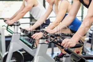 Fit group of people using exercise bike together