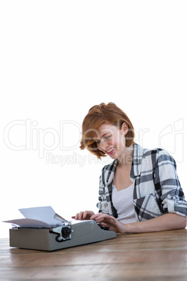 smiling hipster woman typing on her typewriter