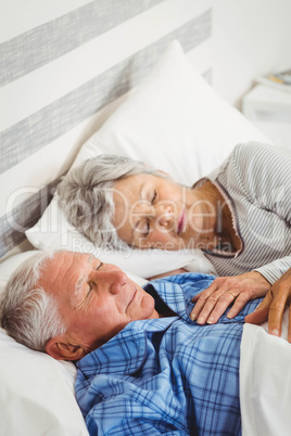 Senior couple sleeping on bed