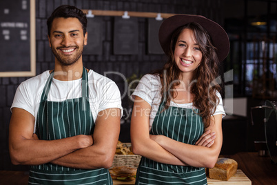 Smiling baristas standing with arms crossed