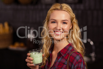 Smiling blonde drinking a beverage