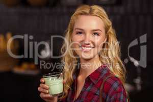 Smiling blonde drinking a beverage