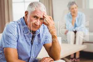 Worried senior man sitting on sofa