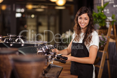 Pretty waitress using the coffee machine