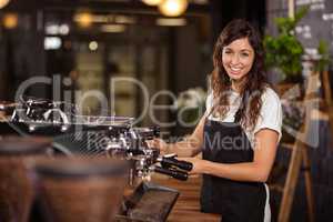 Pretty waitress using the coffee machine