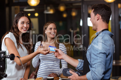 Smiling clients paying with card
