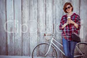 smiling hipster woman with coffee and a biycle