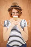 smiling hipster woman drinking a  cup of coffee